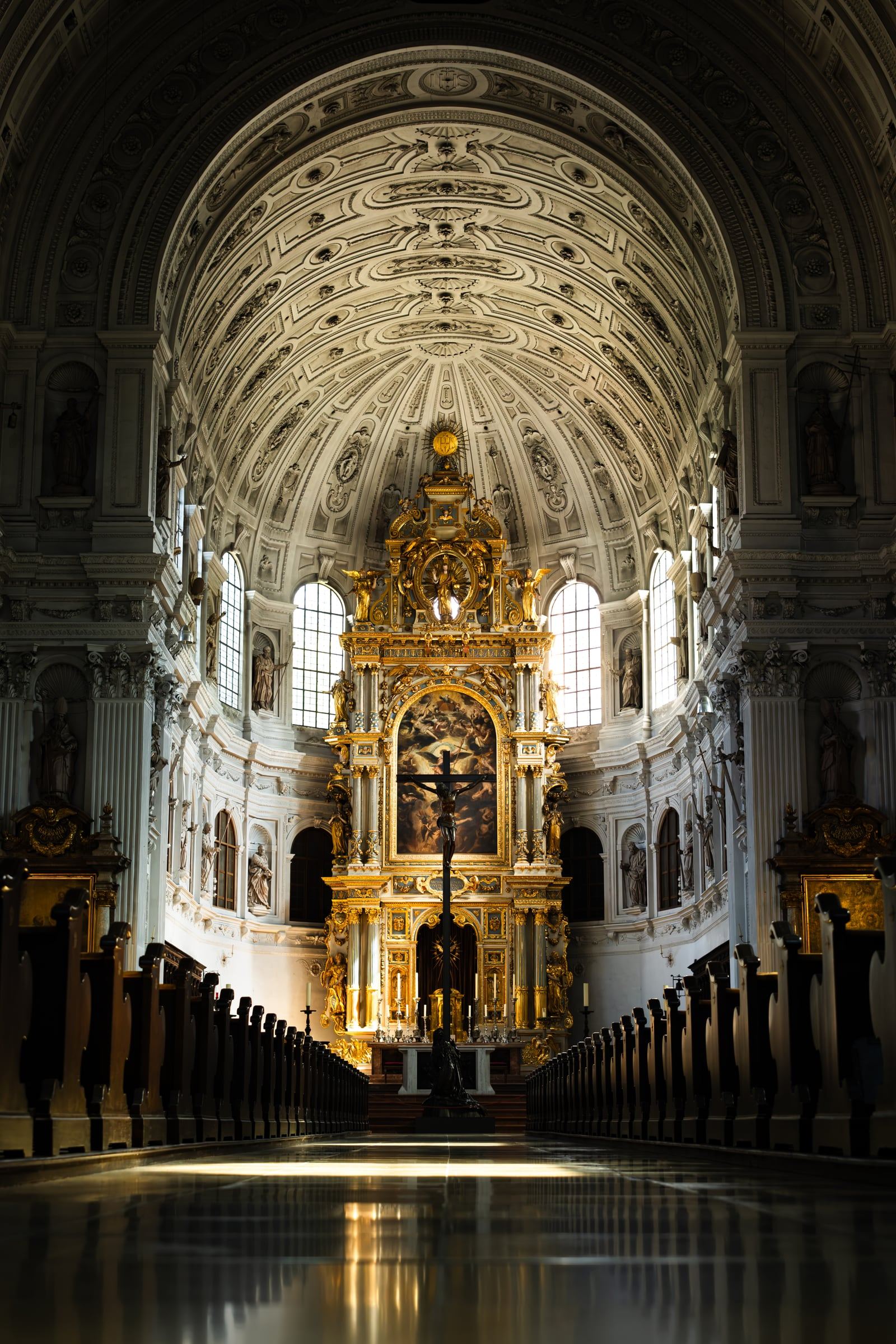 The barrel-vaulted white nave and gilded high altar of St. Michael's Church, with light on the polished floor.
